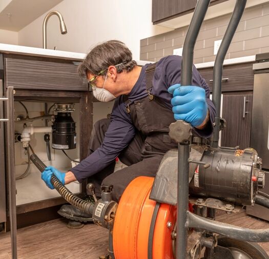Pro Plumber with Facemask Cleaning Drain drain replacement